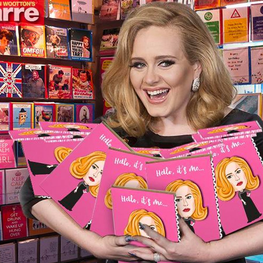 An armful of Tache’s pink Famous Faces cards, held up in a card shop